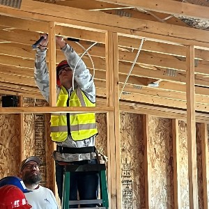 A student works on the electrical wiring of a new house.